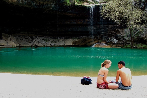 a couple setting next to Hamilton Pool